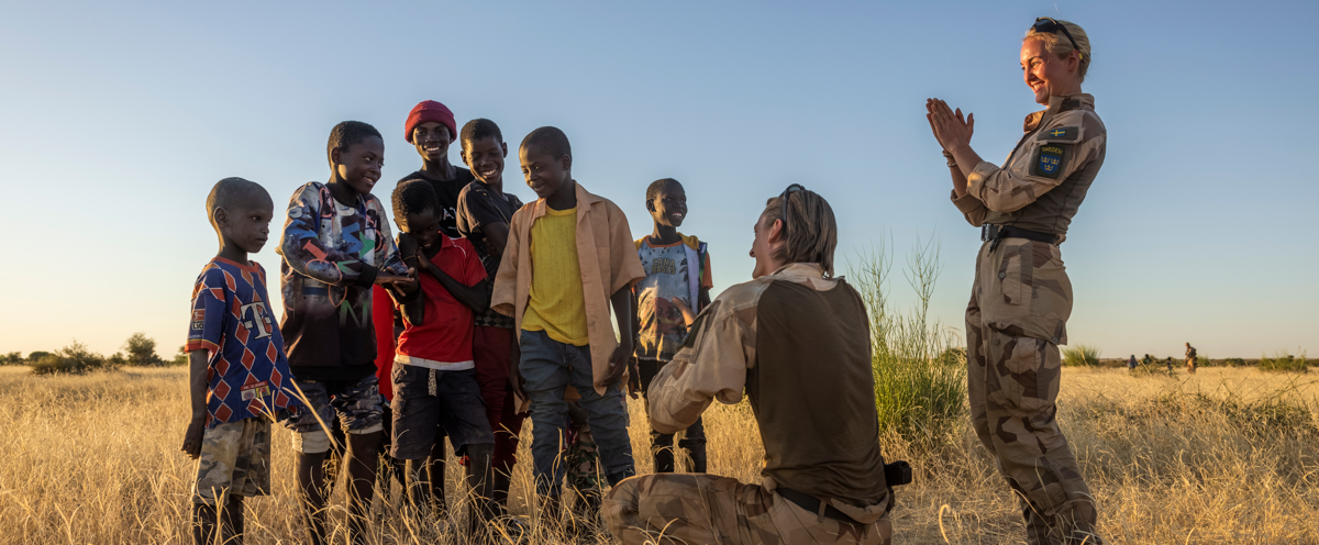 A group of people standing in a field.