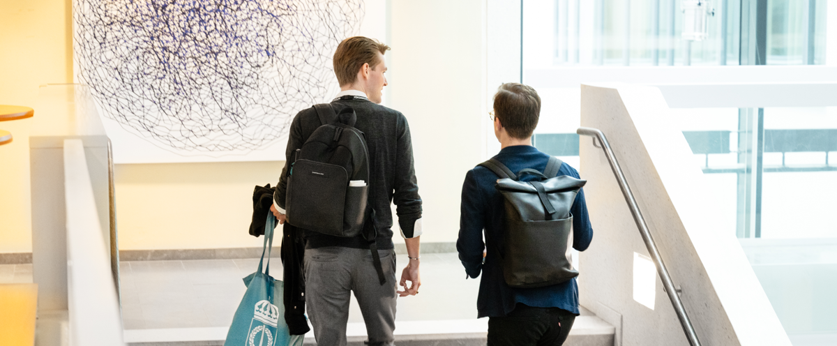 Two young men walking up a flight of stairs.