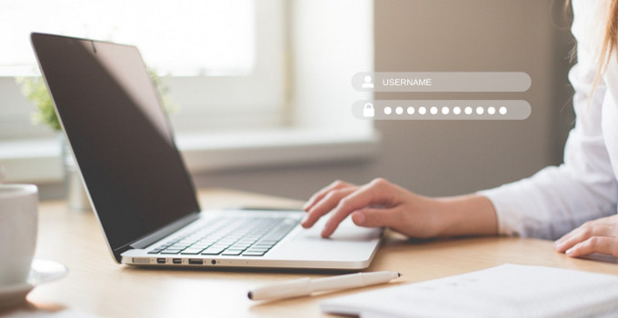 A woman is typing on a laptop computer.