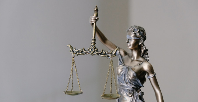 A statue of lady justice holding a scale and a sword.