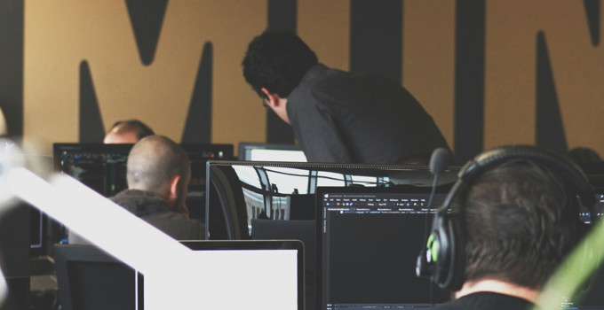 A group of people sitting in front of computer monitors.