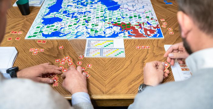 People are sitting at a table playing a board game.
