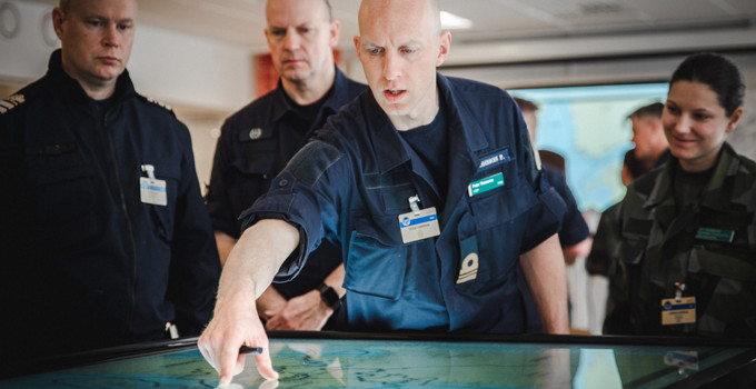 En grupp människor som står runt en karta.