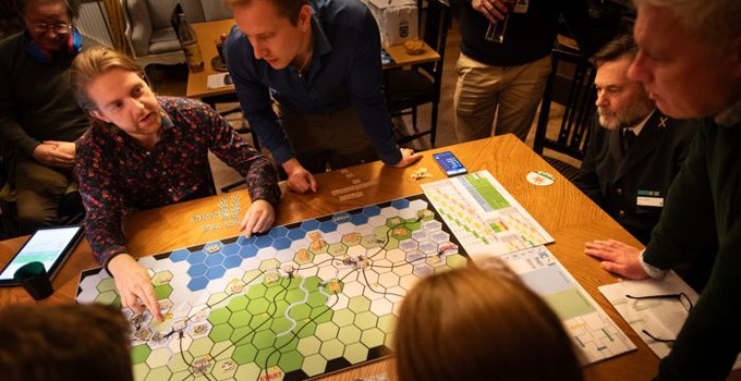 personer runt ett bord med spelbräde på