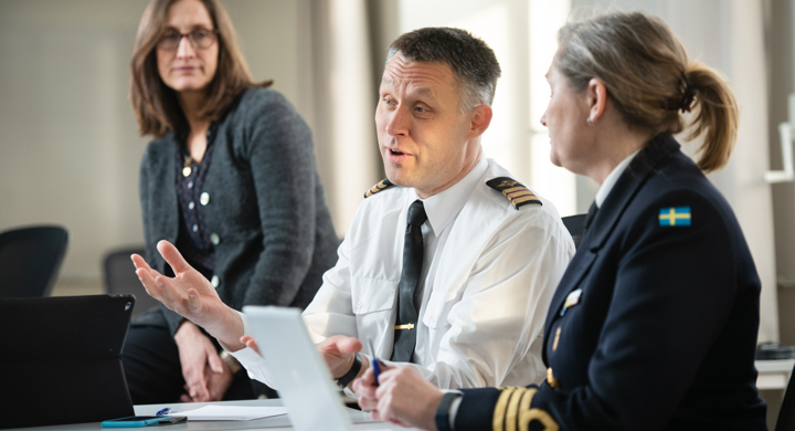 En grupp människor som sitter runt ett bord och pratar.