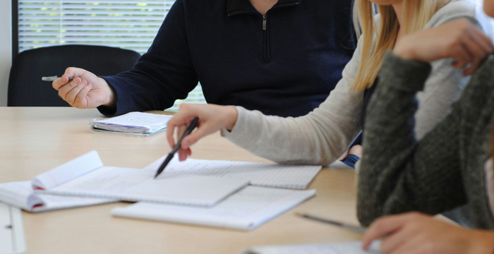 Studenter samarbetar över anteckningsböcker