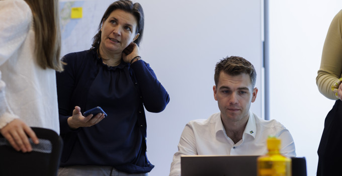 En grupp människor som står runt en bärbar dator.