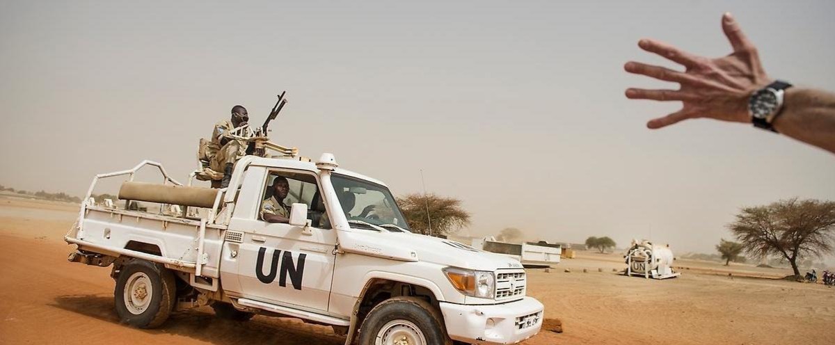 FN-soldater i en vit FN-målad pickup i afrikanskt land.