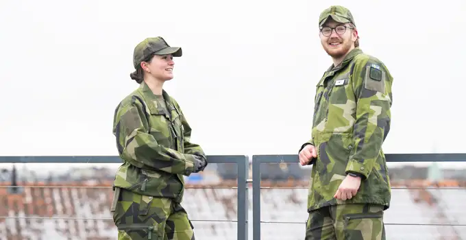 Två kadetter stående på Försvarshögskolans tak.