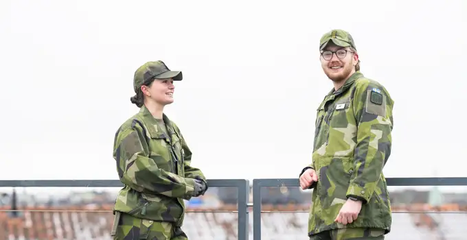 Två kadetter stående på Försvarshögskolans tak.
