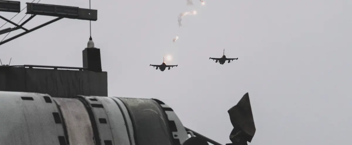Stridsplan som flyger över ett militärfartyg.