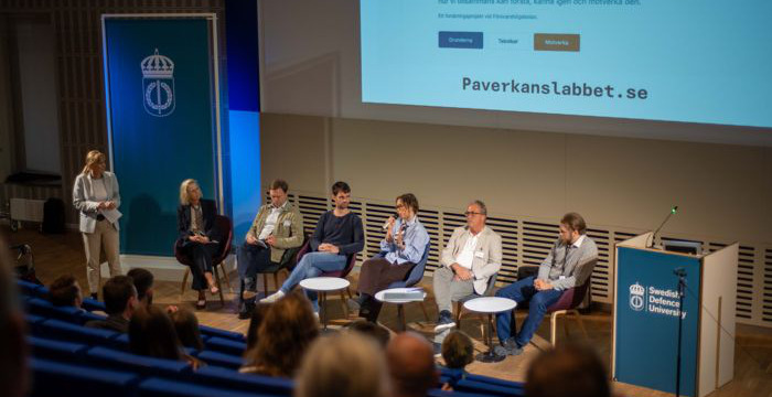 Paneldeltagare på scenen i Sverigesalen vid en konferens.