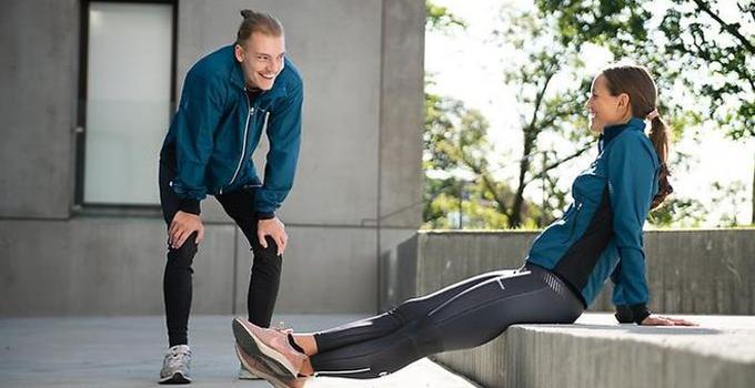 Two students stretching on campus.