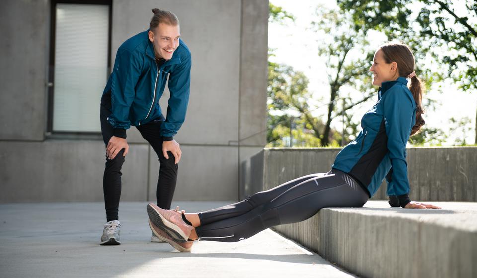 Two students stretching on campus.