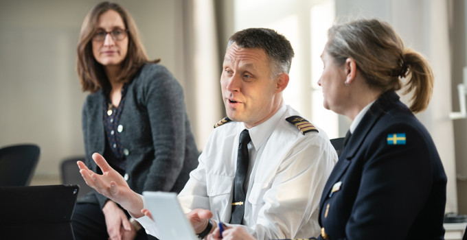 En grupp människor som sitter runt ett bord och pratar.