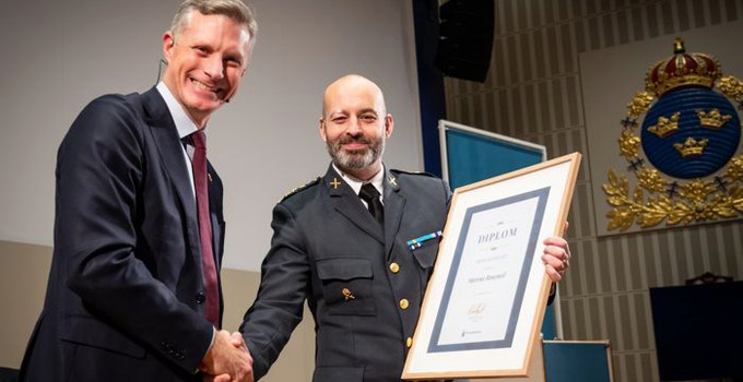 Två personer tar varandra i hand när ett diplom delas ut.