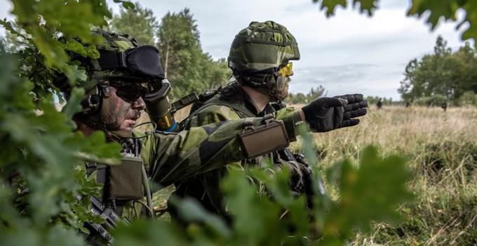 Två  militärer under en övning utomhus.