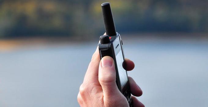 En hand som håller i en kommunikationsradio.