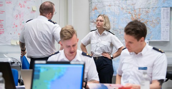 Personer i ett rum under pågående krigsspel.