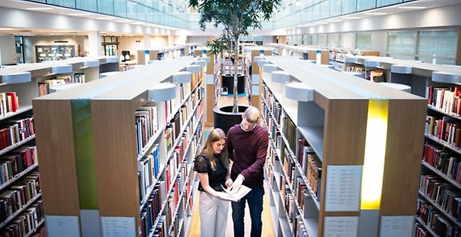 Två studenter i ett bibliotek