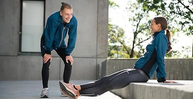 Two students stretching on campus.