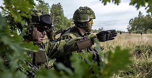 Två  militärer under en övning utomhus.