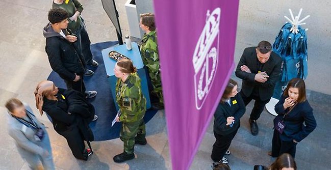 Militärer och civila som minglar i FHS entré.